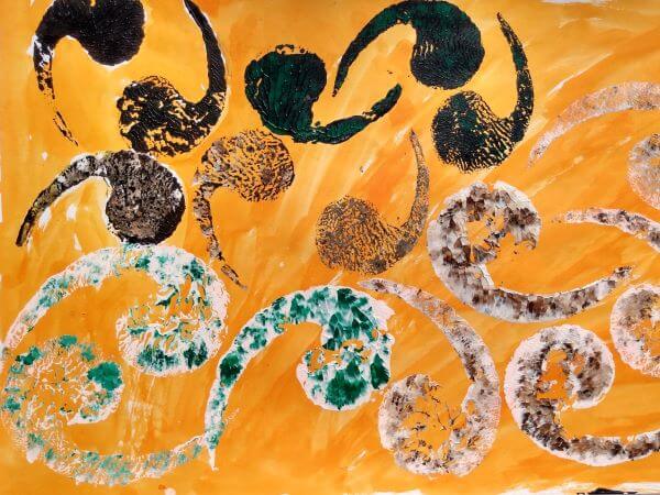 Chocolate curl dessert inspired printed shape in acrylic paints of green, white and brown on a orange background