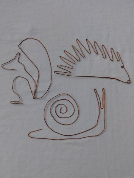 A snail, squirrel and hedgehog outline models each made from a single piece copper wire